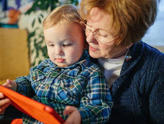 Grandma playing with tablet with young child.