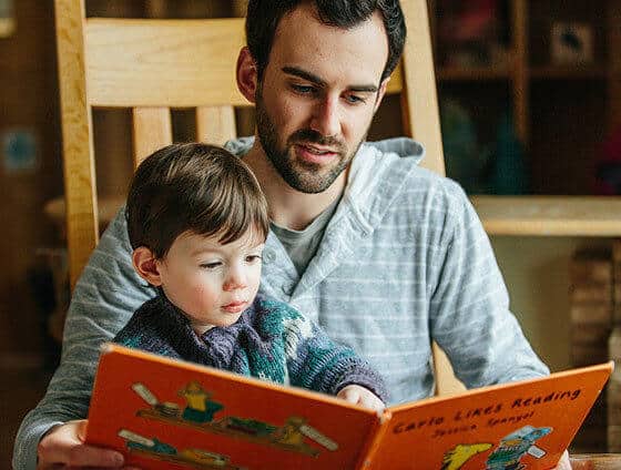 Dad reading with young son.