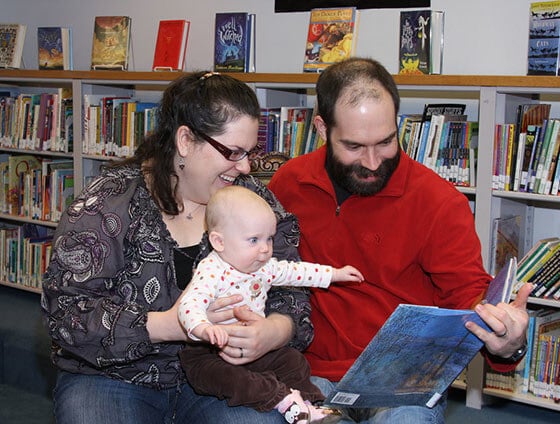 Mom and Dad read to little baby